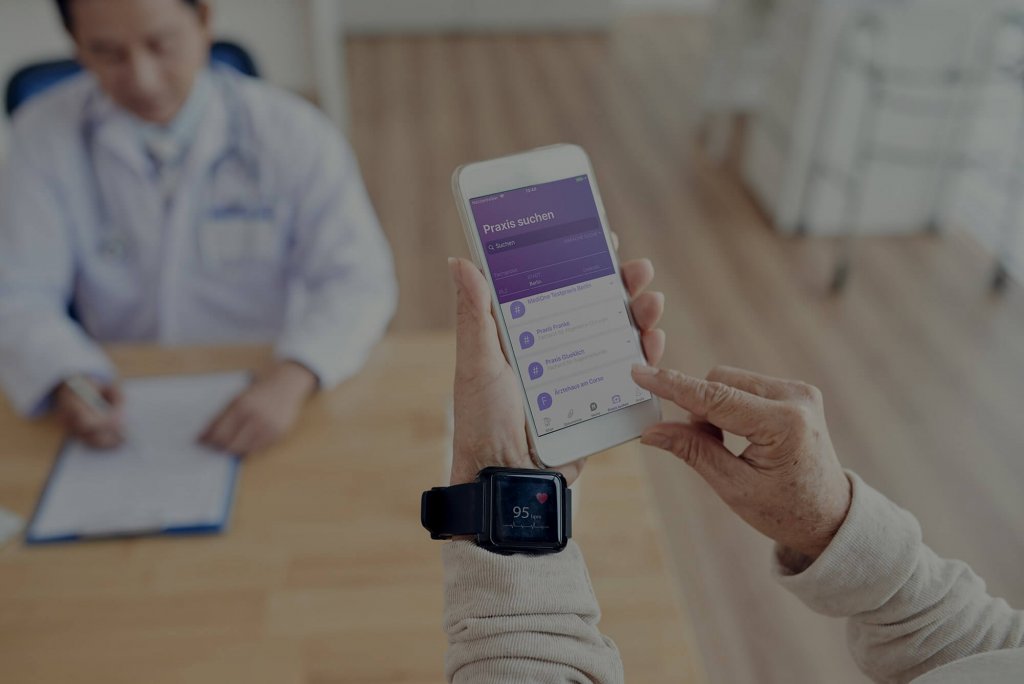 Digitale-Versorgung-Gesetz, Person benutzt Mobile Health-Anwendung vor einem Arzt