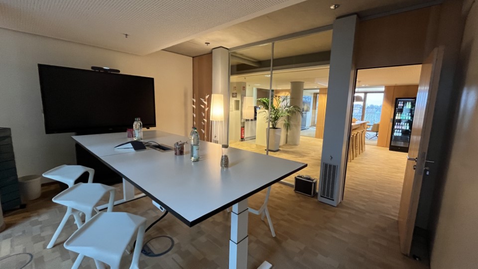 App Entwicklung Hannover | Ansicht des Tagungsraums "Neues Rathaus" mit einem Tisch, Fernseher und Stühlen